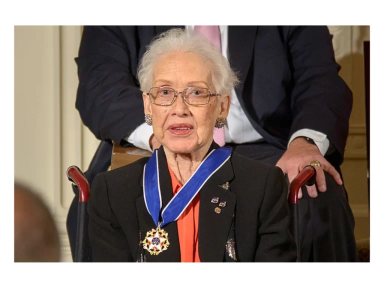Image of Katherine Johnson wearing a medal with someone in the background.